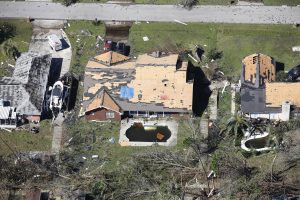 An aerial view of a house severely damaged by a hurricane.